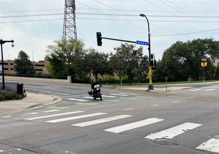 View of city intersection with green crosswalk striping View of city intersection with green crosswalk striping