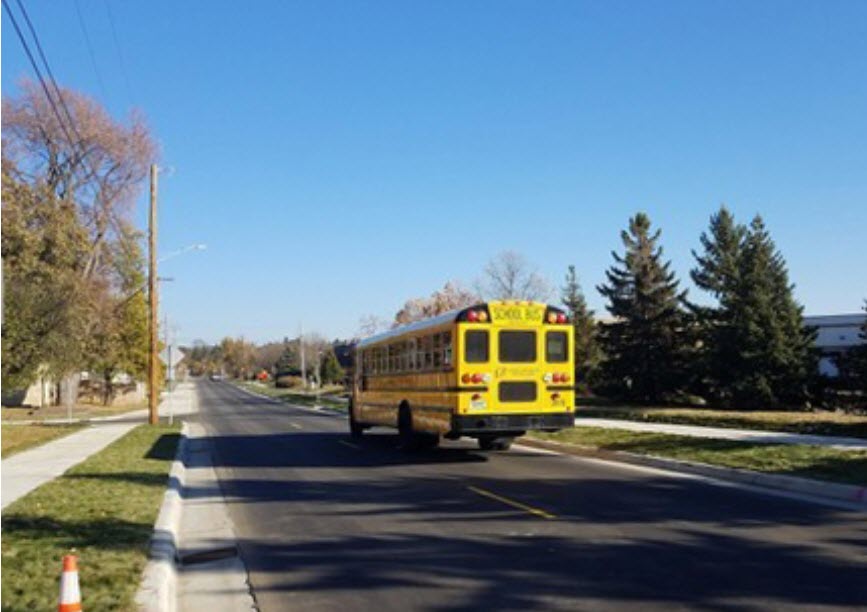 School bus driving along a freshly paved street
