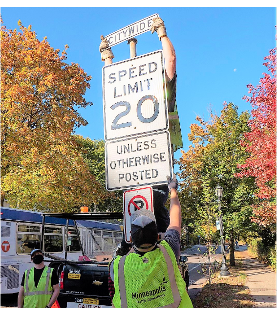 Employee installing 20 mph speed limits sign Employee installing 20 mph speed limits sign