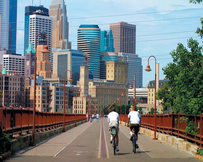 Two people biking across the bridge to downtown Minneapolis