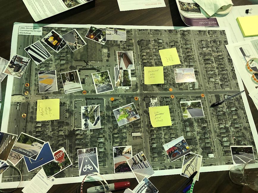 neighborhood map spread on a table with photos and yellow post-it notes