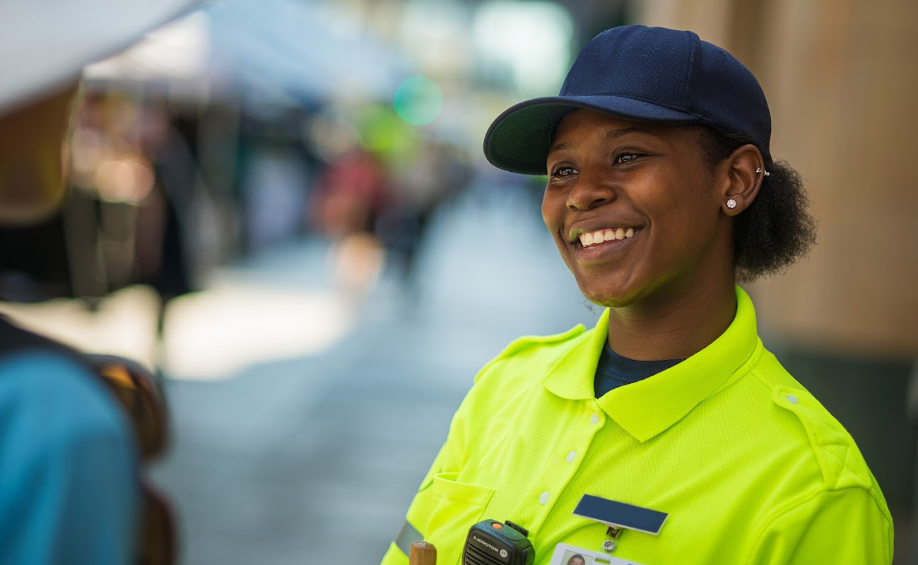 A community safety ambassador smiling at a community member. Photo courtesy of Minneapolis Downtown Improvement District (DID).