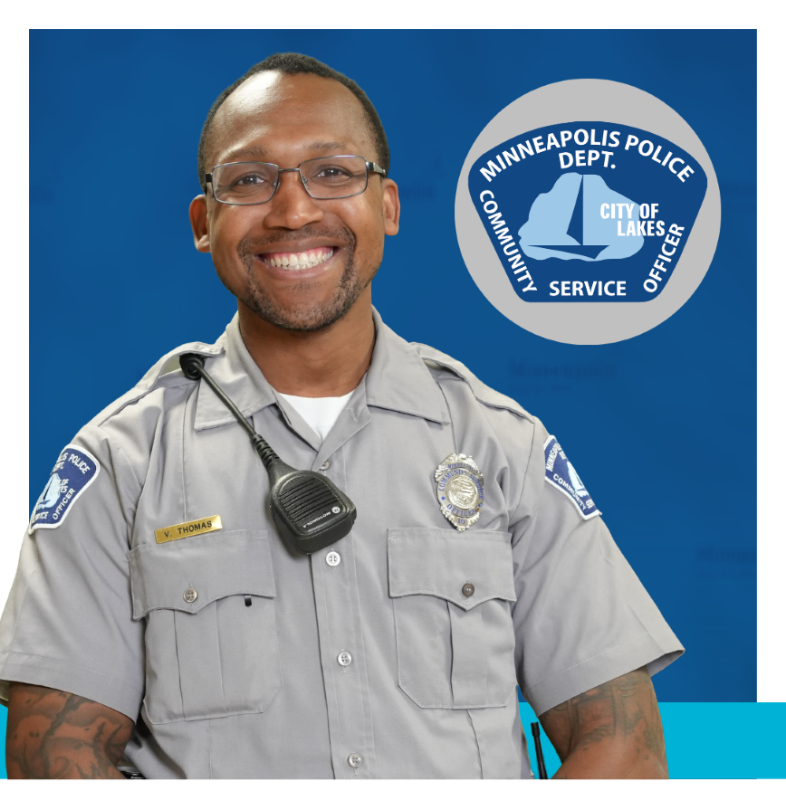 Community Service Officer wearing gray uniform with a blue badge that says Minneapolis Police Dept. City of Lakes Community Service Officer