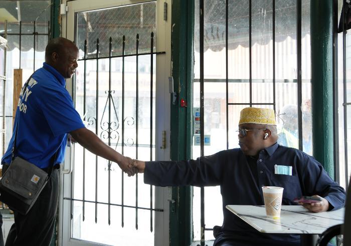 A Community Safety Ambassador shaking hands with a community member. A Community Safety Ambassador shaking hands with a community member.