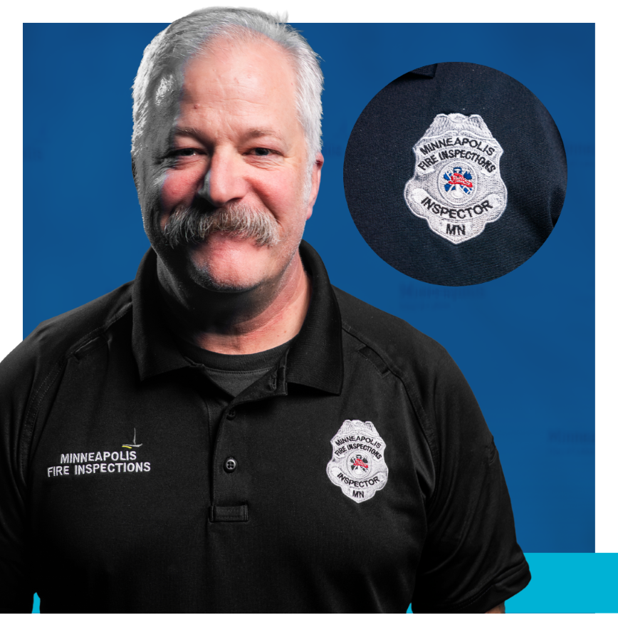 Fire Inspections Inspector wearing black shirt and silver badge that says Minneapolis Fire Inspections Inspector MN