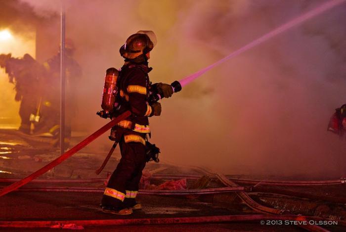 Minneapolis firefighter spraying water on a fire Minneapolis firefighter spraying water on a fire