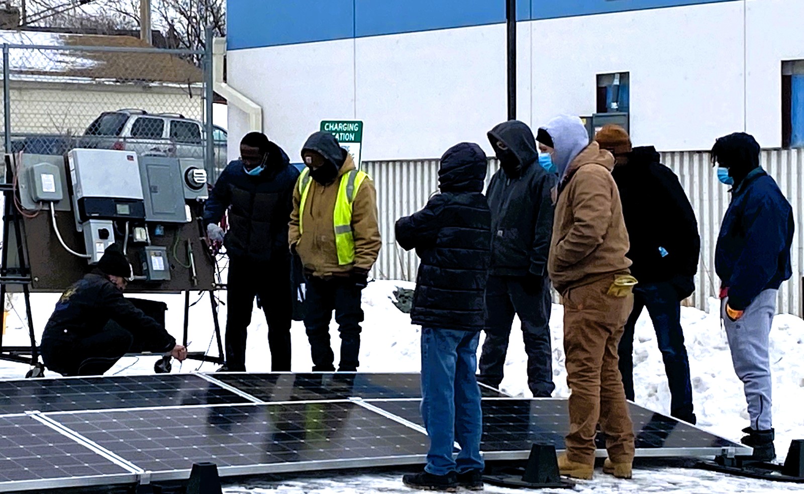 People standing by solar panel