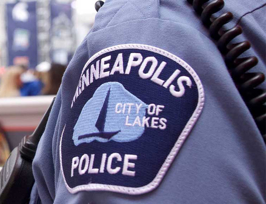 Minneapolis police patch on officer standing in a street