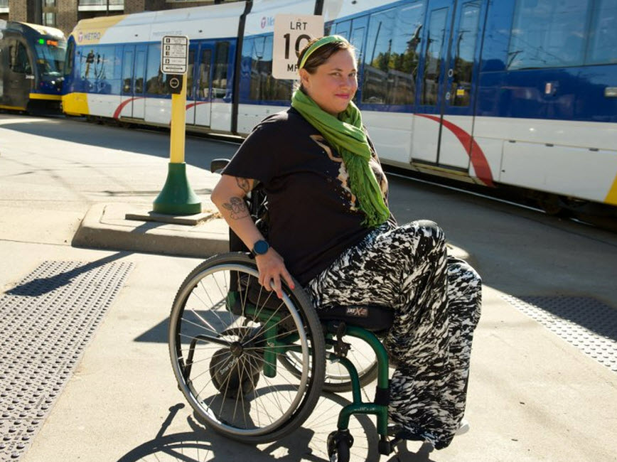 Person in wheelchair in front of Light rail. Photo by Meet Minneapolis.