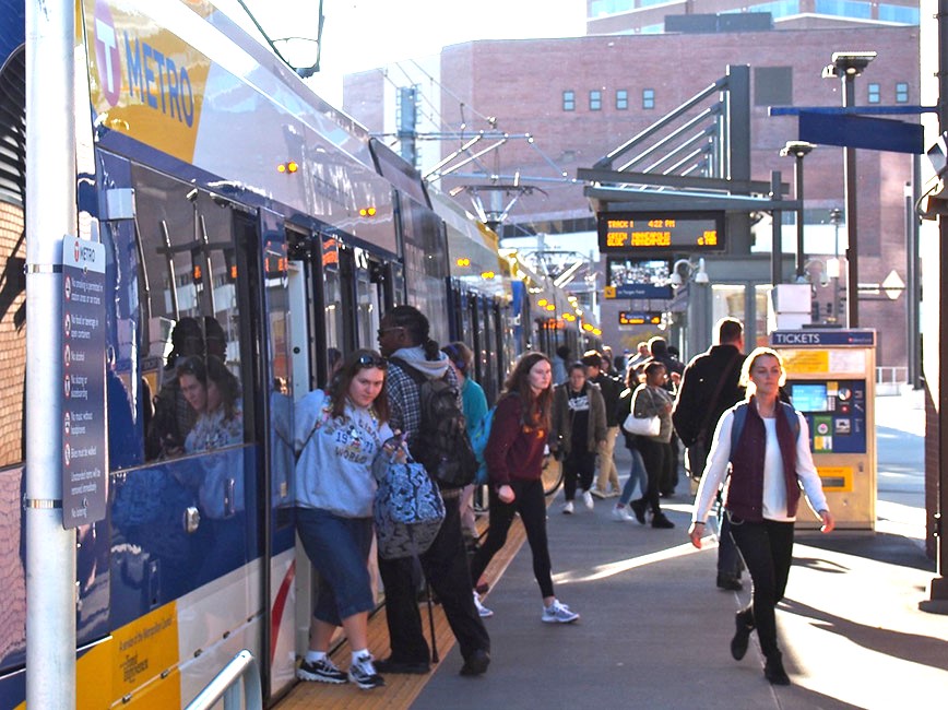 Metro riders enter and exit a train stopped at a station in Minneapolis.