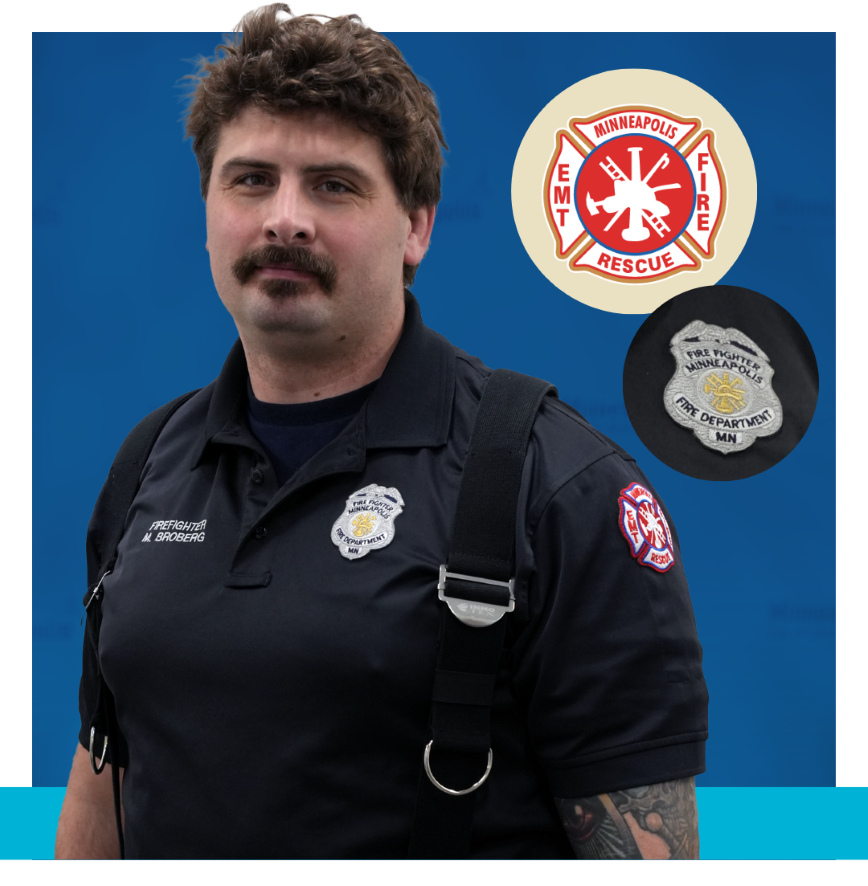 Minneapolis Firefighter wearing black uniform with badges that say Firefighter Minneapolis Fire Department MN and Minneapolis EMT Fire Rescue