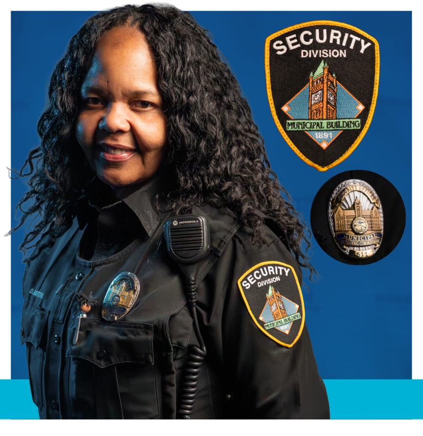 Municipal Building Commission Security wearing a black uniform and badges that say security division municipal building and security officer municipal building commission