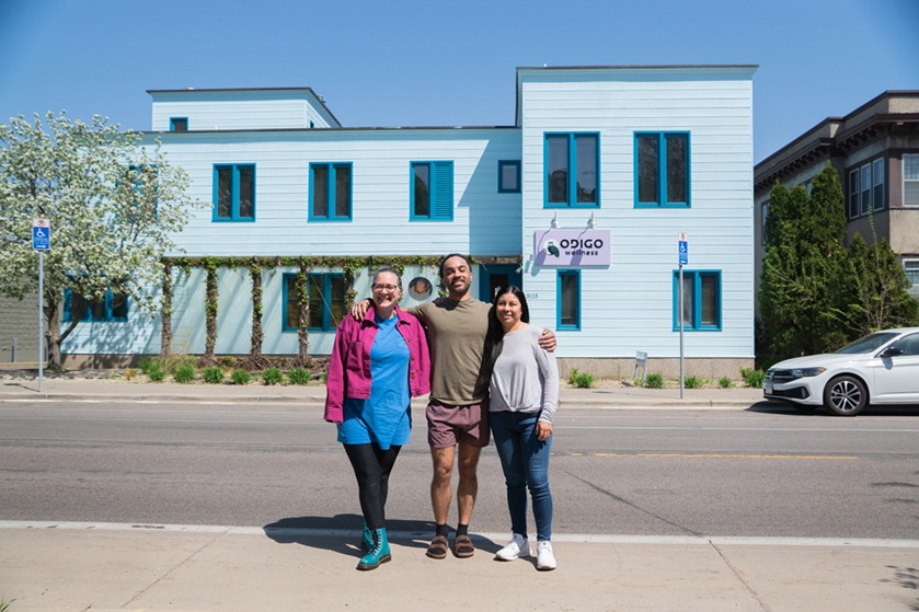 Three people standing outside of a building
