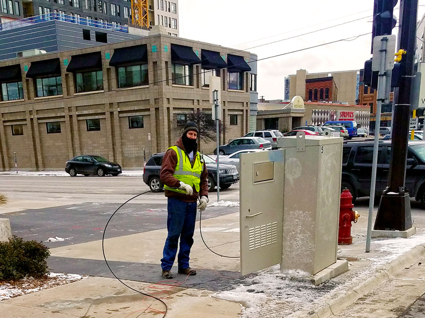 City staff person in winter adjusting traffic signal City staff person in winter adjusting traffic signal