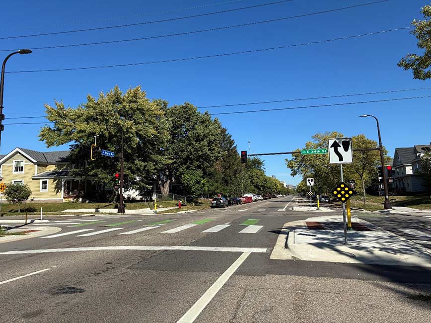 A tree-lined street with a corner bump-out for crossing. A tree-lined street with a corner bump-out for crossing.
