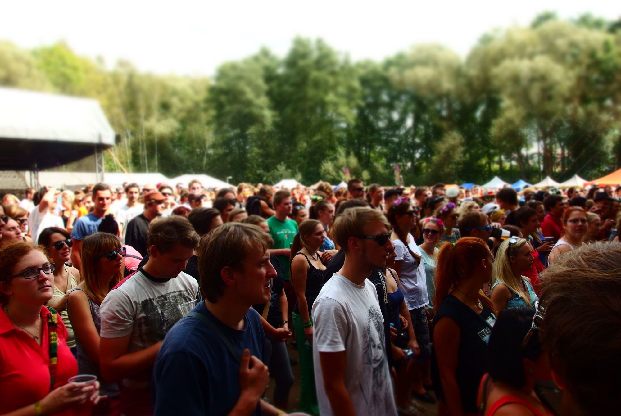 A crowd of people close together outside.