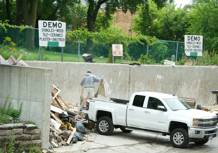 resident unloading building materials from pickup truck
