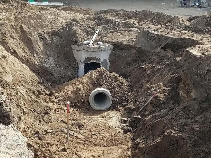 Sewer manhole and pipe extending towards viewer