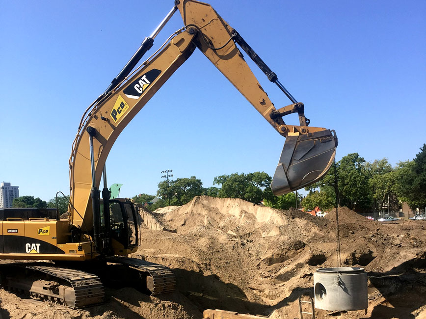 Excavator laying pipe.