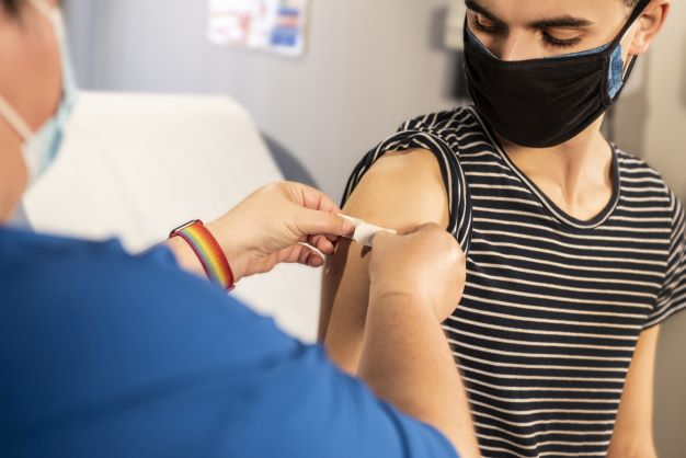 Person wearing a mask receiving a shot