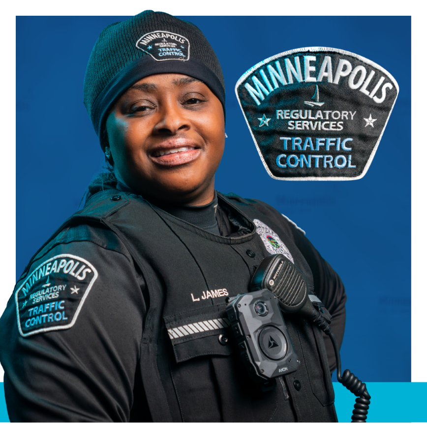 Traffic control person wearing black uniform with badge that says regulatory service traffic control