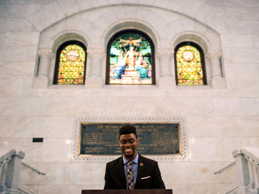 Scholar speaking at a podium