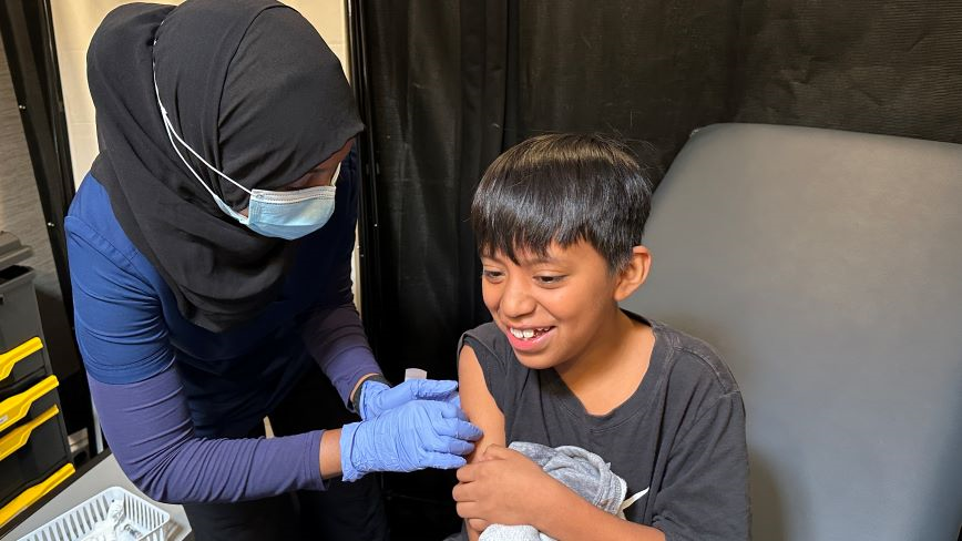 nurse giving child vaccine