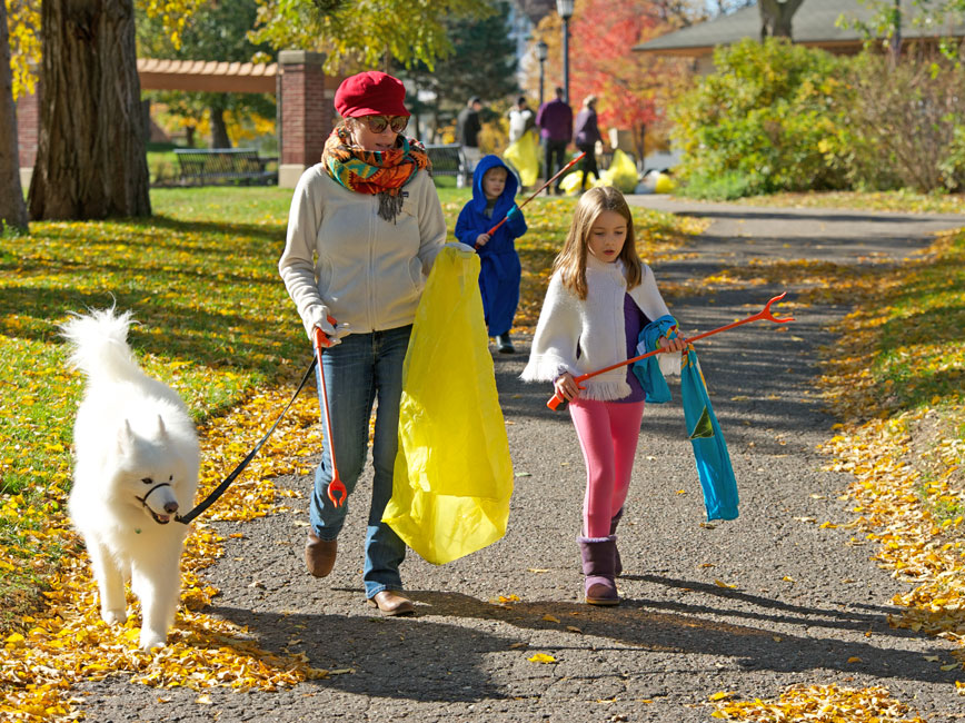 woman, child walk dog while picking up litter