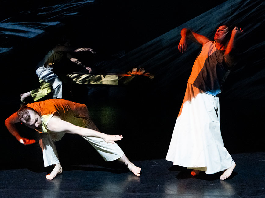 Two dancers performing in colored light. Photo by Rosy Simas.