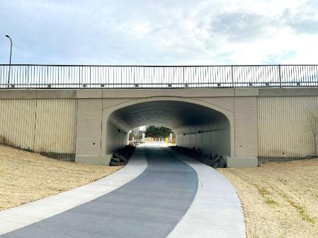 Pathway leading under a road through a tunnel.