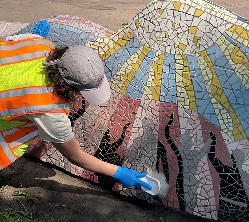 Artist Laura Kubick touching up her mosaic art.