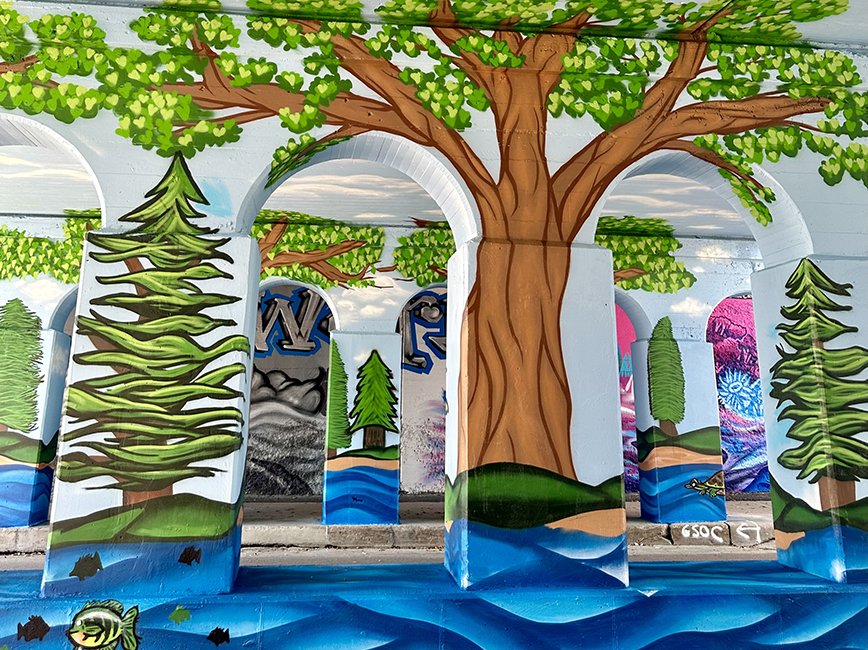 Mural painted on arches sowing tree and water in nature.