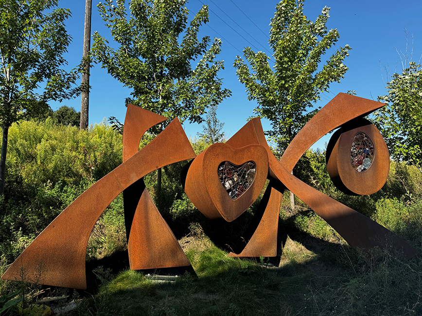 A brown metal sculpture in the shape of the letters XOXO
