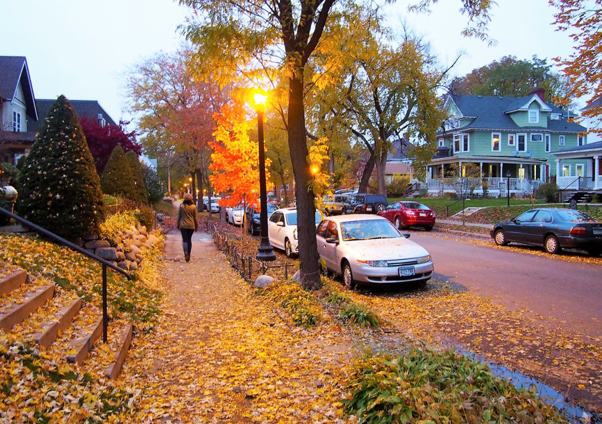 Person walking sidewalk in autumn