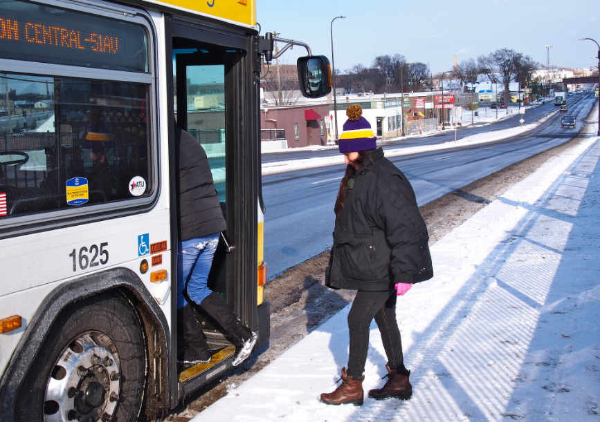 Person stepping onto a bus in the snow