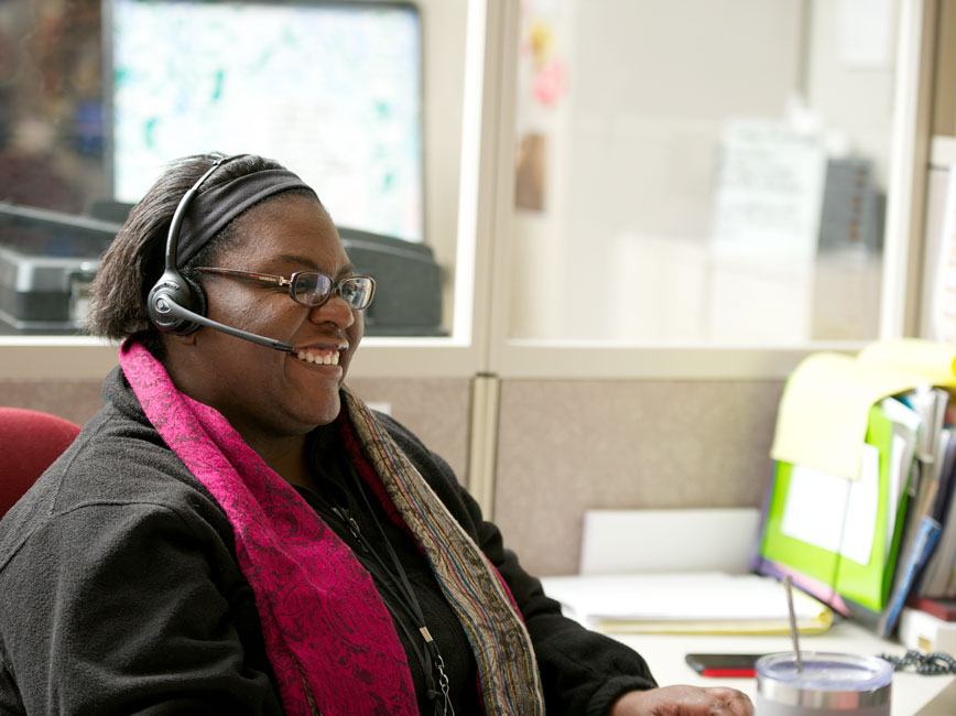 A smiling 311 agent helping a caller