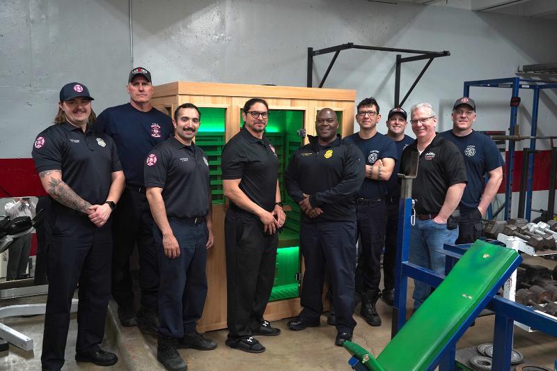 A group of firefighters pose in front of a donated sauna. A group of firefighters pose in front of a donated sauna.