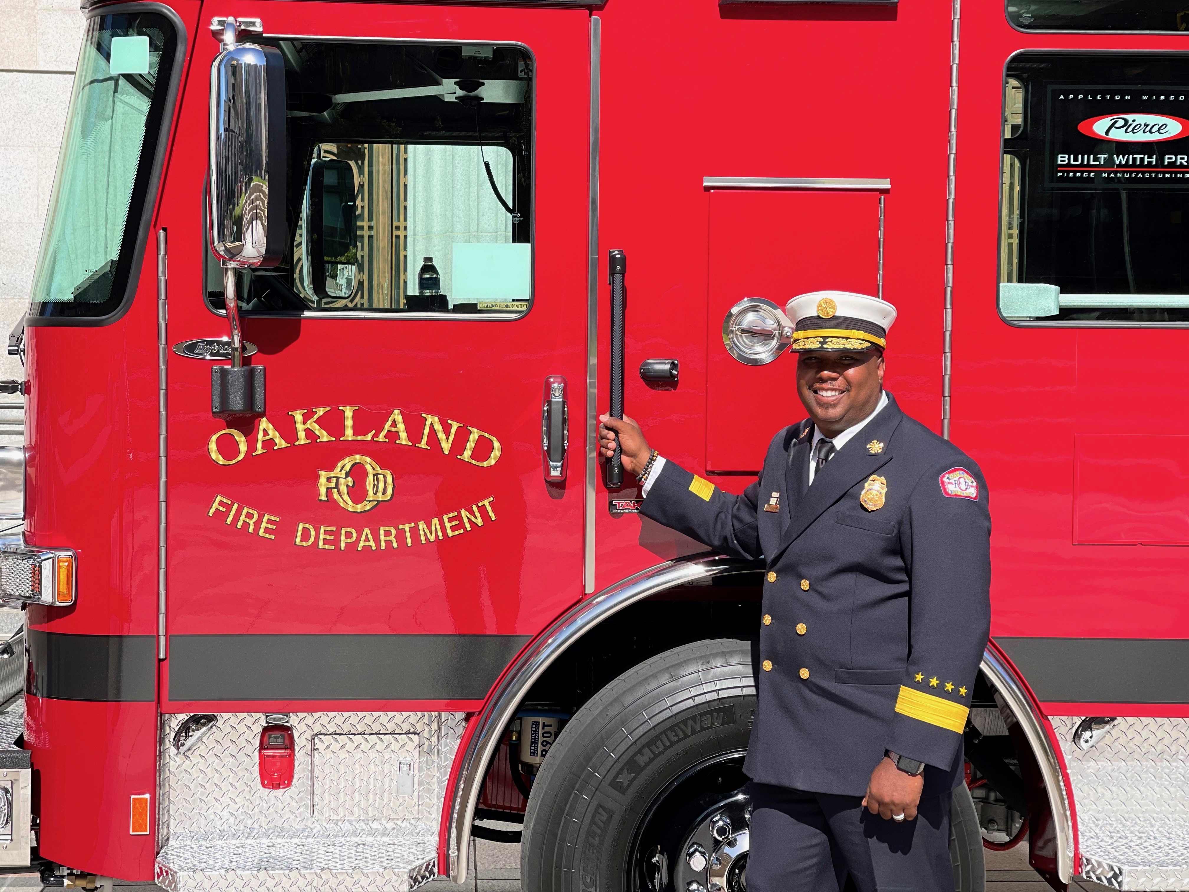 Dr. Reginald Freeman poses in front of an Oakland Fire Department rig.