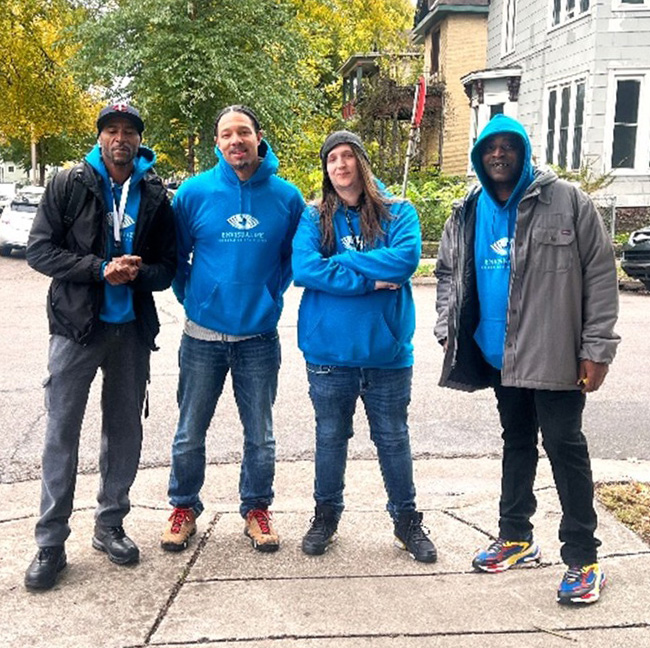 Four members of EnVisualize standing in a neighborhood