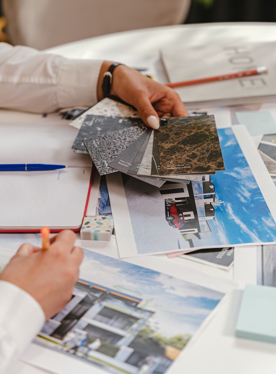 Person holding building samples over a table of plans