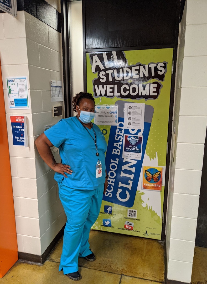 Person in scrubs at door to clinic Person in scrubs at door to clinic