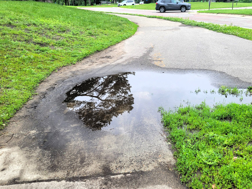Sidewalk with water puddle near Minnehaha park Sidewalk with water puddle near Minnehaha park