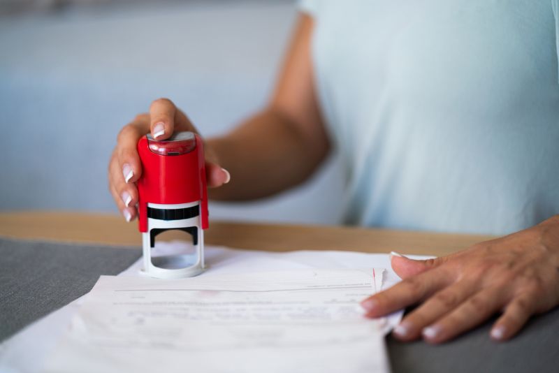 Close-up of person stamping a document