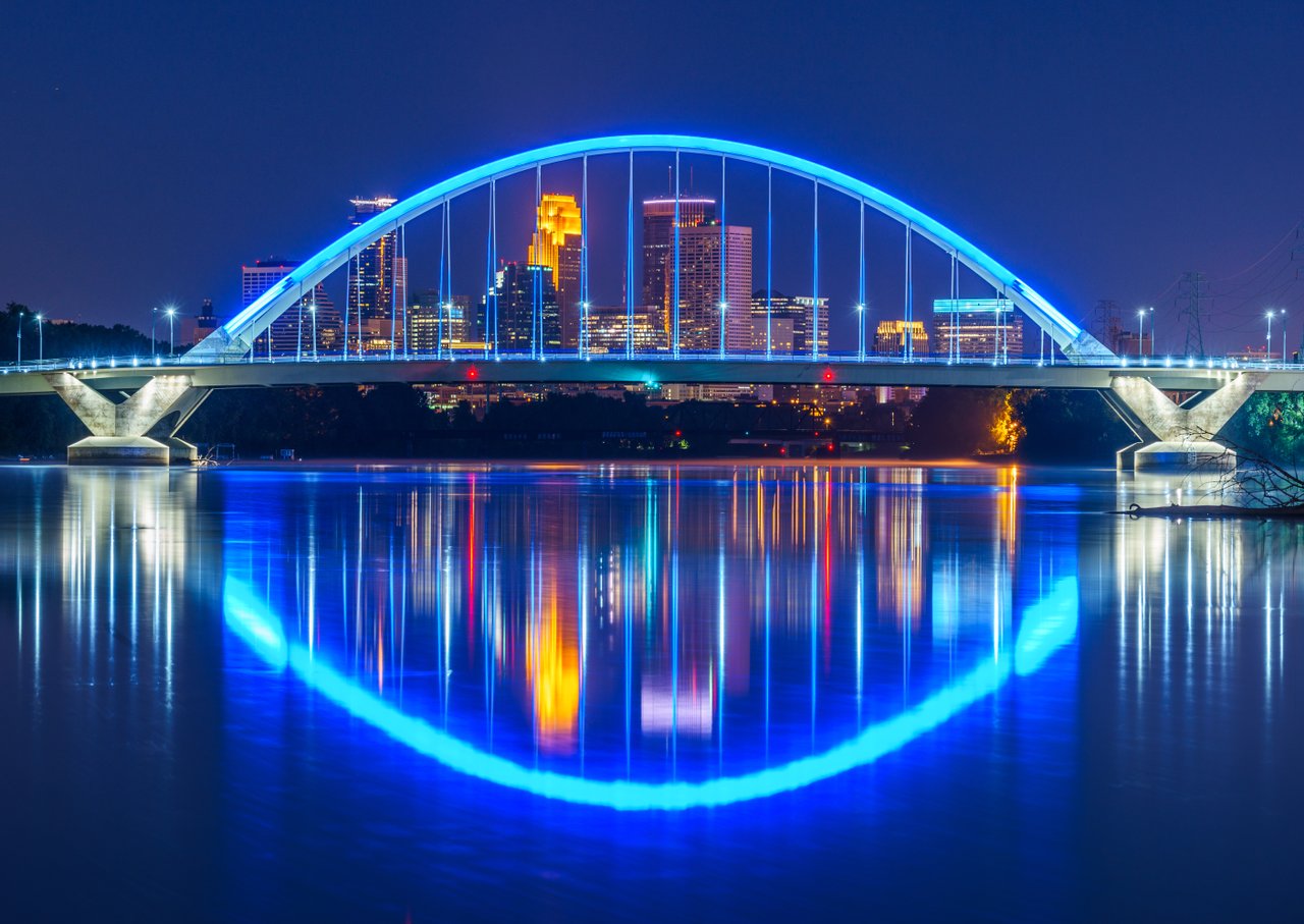 Looking through the Lowry Ave. Bridge to downtown Minneapolis at night; Photo by Lane Pelovsky, Courtesy Meet Minneapolis