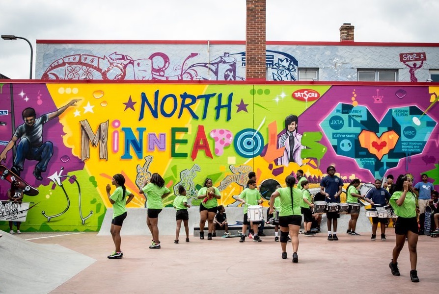 People dancing in front of North Minneapolis mural. Credit Rebecca Rabb Courtesy of Meet Minneapolis.