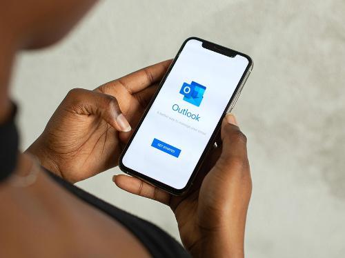 A person setting up Outlook on a cellphone