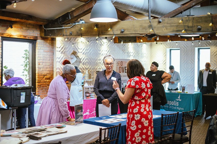 People standing around tables talking People standing around tables talking