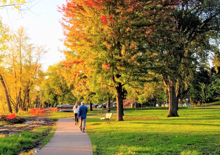 People walking by Lake Nokomis in the fall