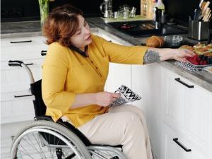 Person on phone while reaching for food on the kitchen counter