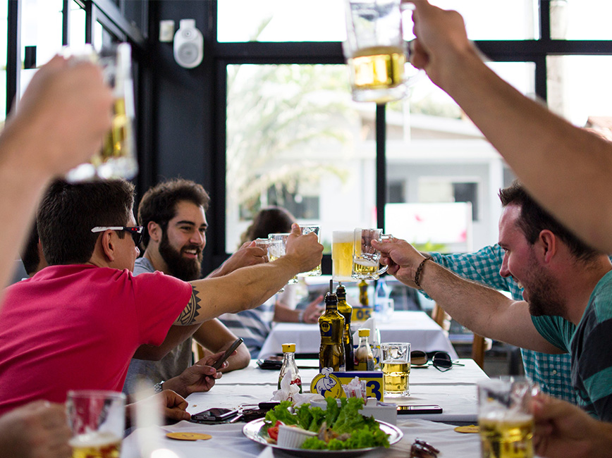 People clicking drinks together in a taproom